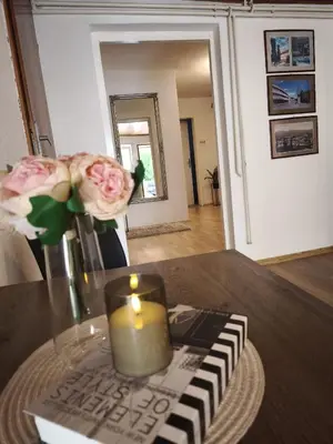 a candle and flowers on a table in a living room at Malta in Livno