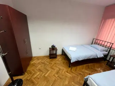 a bedroom with two beds and a wooden floor at StayBihac in Bihać