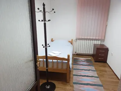 a small bedroom with a bed and a pole at StayBihac in Bihać