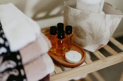 a shelf with two bottles of essential oils and towels at Villa Natura in Bosanska Gradiška