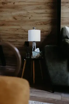 a lamp on a table next to a chair at Villa Natura in Bosanska Gradiška