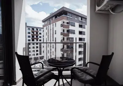 a balcony with a table and chairs and a building at Dolce notte in Železnička Stanica Incel