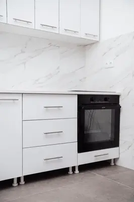 a white kitchen with white cabinets and a stove at Dolce notte in Železnička Stanica Incel