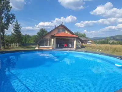 a large swimming pool in front of a house at Holiday home Biskupici in Visoko