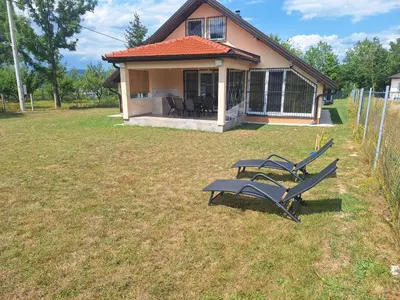 a picnic table and chairs in a yard in front of a house at Holiday home Biskupici in Visoko