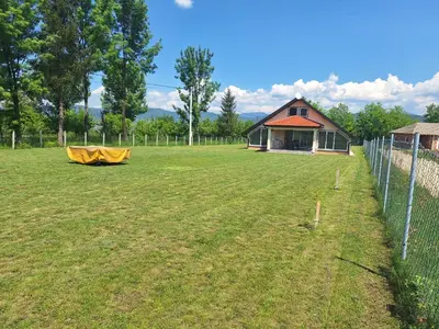 a field with a fence and a house at Holiday home Biskupici in Visoko