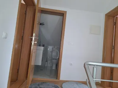 a bathroom with a toilet through a glass door at Holiday home Biskupici in Visoko