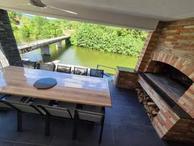 a patio with a table and a brick fireplace at Apartmani Vanilla in Zavidovići