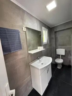 a bathroom with a white sink and a toilet at Apartmani Vanilla in Zavidovići