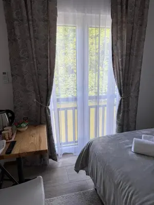 a bedroom with a bed and a large window at Apartmani Vanilla in Zavidovići
