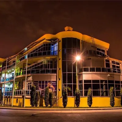 a large building with a lot of windows at night at Hostel Fortuna in Banja Luka