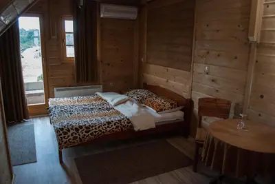a bedroom with a leopard print bed and a table at Hostel Fortuna in Banja Luka