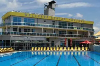 a large building with a swimming pool in front of it at Hostel Fortuna in Banja Luka