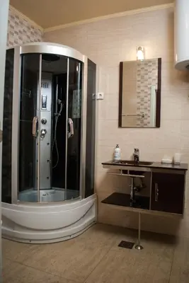 a bathroom with a shower and a sink and a mirror at Hostel Fortuna in Banja Luka