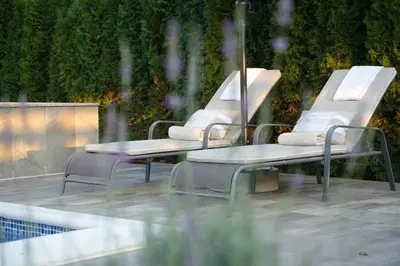three chairs and a table next to a pool at LUXIA PRIVATE ESTATE Sauna & Outdoor lounge with Fireplace in Bihać