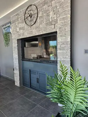 a garage door with a clock on a brick wall at LUXIA PRIVATE ESTATE Sauna & Outdoor lounge with Fireplace in Bihać