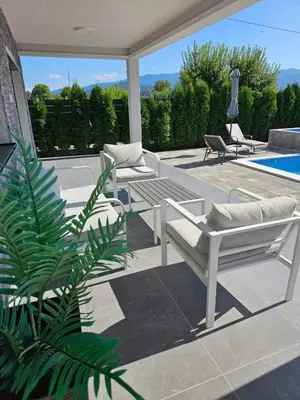 a patio with two benches and a swimming pool at LUXIA PRIVATE ESTATE Sauna & Outdoor lounge with Fireplace in Bihać