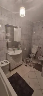 a bathroom with a sink and a toilet and a mirror at Apartman Ivan in Tomislavgrad