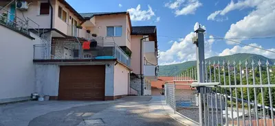 a house with a gate and a garage with a mountain at Bella vista in Jajce