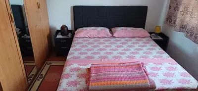 a bedroom with a bed with pink sheets and pink pillows at Bella vista in Jajce