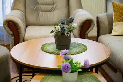 a coffee table with a vase of flowers on it at GRADINA - Stan na dan in Doboj