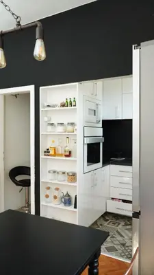 a kitchen with white cabinets and a black wall at Banja Luka Apartment Brigita in Banja Luka