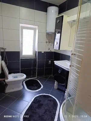 a bathroom with a toilet and a sink and a window at Apartman Omar in Bihać