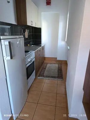 a kitchen with white appliances and a tile floor at Apartman Omar in Bihać
