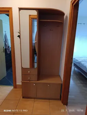 a wooden cabinet with a mirror in a room at Apartman Omar in Bihać