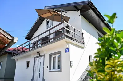 a white building with a balcony on top of it at Apartman Nina in Jajce
