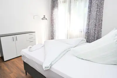 a bedroom with a white bed and a window at Apartman Nina in Jajce