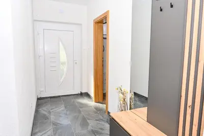 a hallway with a white door and a mirror at Apartman Nina in Jajce
