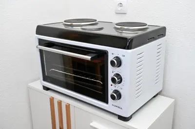 a toaster oven sitting on top of a white cabinet at Apartman Nina in Jajce