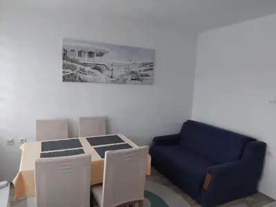 a living room with a table and a blue couch at Apartman Breskvica in Bihać