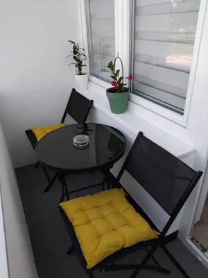 a table and chairs in a room with a window at Apartman Breskvica in Bihać