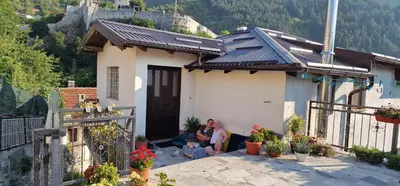 two people sitting in front of a small house at Apartment Plava Voda in Travnik