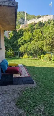 a bed with pillows sitting on top of a lawn at Apartment Plava Voda in Travnik