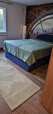a bed in a room with a brick wall at Apartment Plava Voda in Travnik