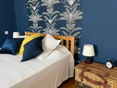 a bedroom with a bed and a blue wall at Cozy&Arty House with Garden&Parking- in the centre in Banja Luka