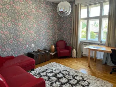 a living room with a red couch and a table at Cozy&Arty House with Garden&Parking- in the centre in Banja Luka