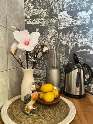 a table with a vase and a plate with lemons and a flower at Cozy&Arty House with Garden&Parking- in the centre in Banja Luka
