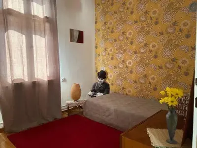 a child sitting on a bed in a bedroom at Cozy&Arty House with Garden&Parking- in the centre in Banja Luka