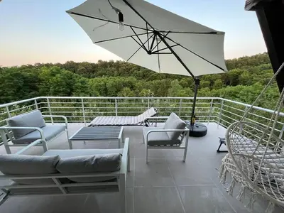 a patio with chairs and a table and an umbrella at Vikendica Bregovi in Doboj