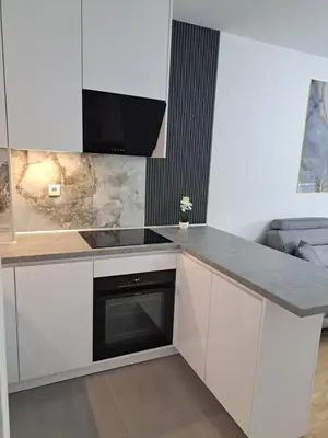 a kitchen with white cabinets and a black oven at Apartman So Chic kod Kastela in Banja Luka