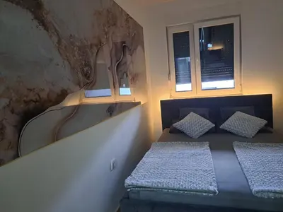 a bedroom with a bed and two windows at Apartman So Chic kod Kastela in Banja Luka