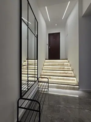 a hallway with stairs with a chair and a door at Suite M in Livno