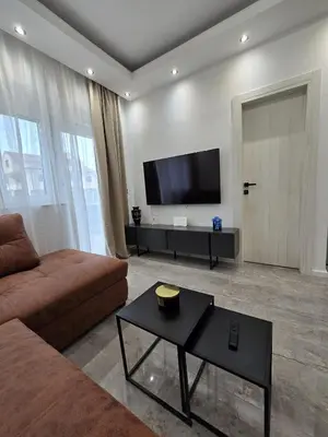 a living room with a couch and a flat screen tv at Suite M in Livno