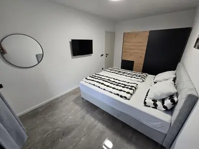 a bedroom with a large bed and a mirror at Suite M in Livno