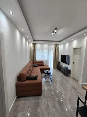 a living room with a brown couch and a television at Suite M in Livno
