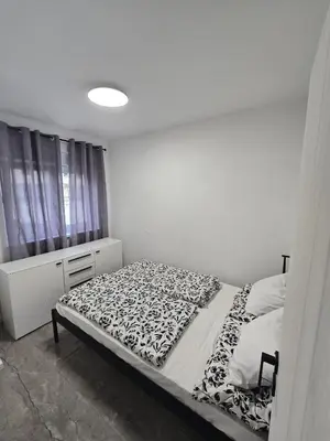 a bedroom with a bed with a black and white blanket at Suite M in Livno